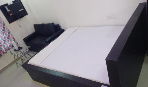 a bed and a chair in a room at Sea Land Mandarmani in Mandarmoni