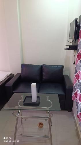 a living room with a black couch and a table at Sea Land Mandarmani in Mandarmoni