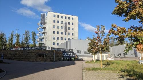 duży biały budynek z znakiem przed nim w obiekcie Truck-Parking A8 w mieście Heimsheim