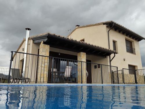 a house with a swimming pool in front of a house at Casa Rural Raiztruf in Cinctorres