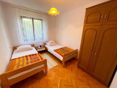 a small room with two beds and a cabinet at Apartmani Ružić in Jadranovo