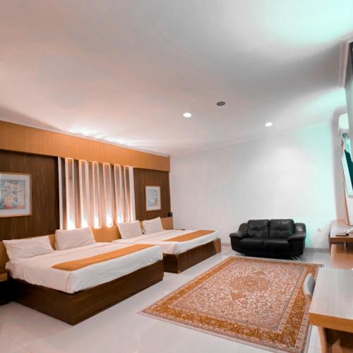Un dormitorio con 2 camas y una silla. en DINASTY STYLE HOTEL SOLO, en Bonorejo