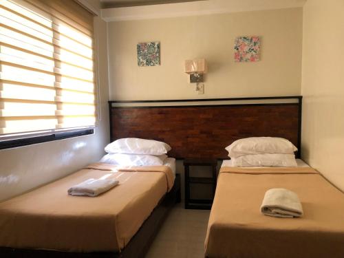 a bedroom with two beds with towels on them at Delle Suites in General Santos