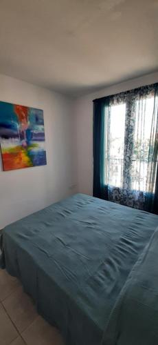 Un dormitorio con una cama grande y una ventana en Jolie maisonnette à proximité de toutes commodités, en Saintes-Maries-de-la-Mer