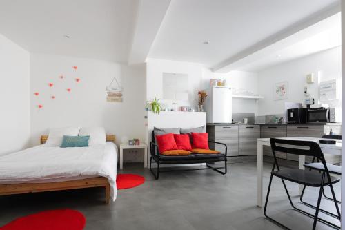 1 dormitorio con cama, mesa y cocina en Charmant studio, au cœur de la ville de Riom en Riom