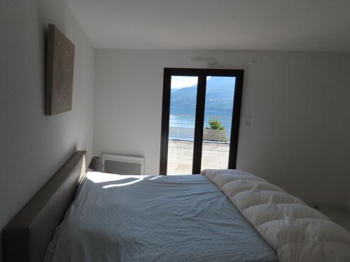 a bedroom with a bed with a view of the beach at leparadisachorges in Chorges
