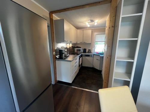 a small kitchen with white cabinets and a table at Ferienhaus Zeulenrodaer Meer in Stelzendorf