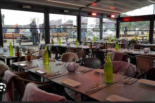 a restaurant with tables and chairs with green bottles at Basement apartment in Sandefjord