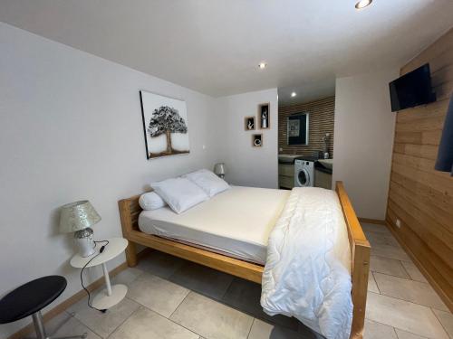 a bedroom with a bed and a table and a chair at Les 3 marguerites in Luzenac