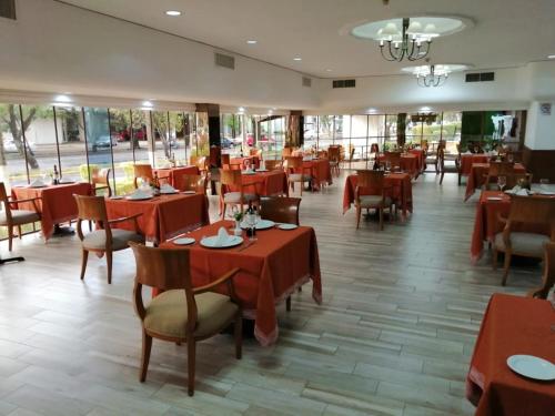 a dining room with red tables and chairs at Holiday Inn Morelia by IHG in Morelia