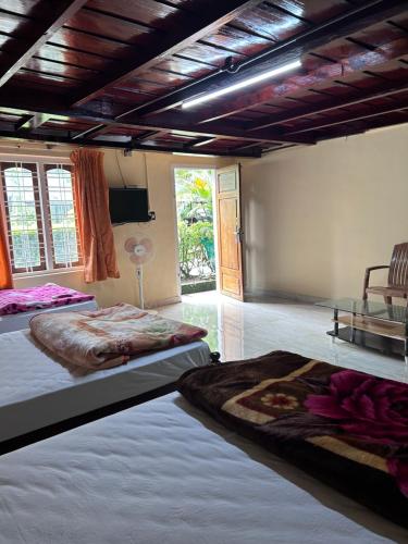 Un dormitorio con dos camas en una habitación. en puthussery homestay, en Anachal