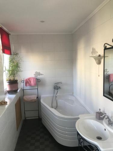ein weißes Badezimmer mit einer Badewanne und einem Waschbecken in der Unterkunft Андреевская мансарда»у Амура» in Kiew