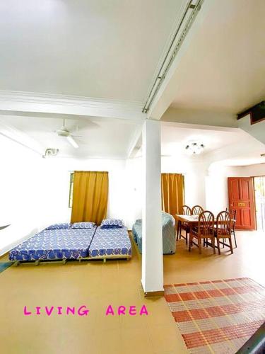 a living area with two beds and a dining room at Budget House Near Penang Airport Bayan Lepas Penang in Bayan Lepas