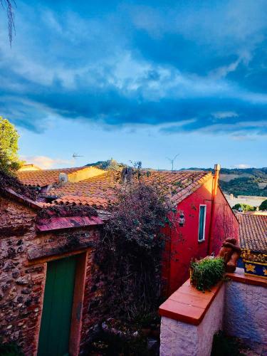 a red building with a green door and a roof at Vue exceptionnelle sur la baie de Collioure in Collioure