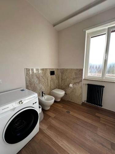 ein Badezimmer mit einem WC und einer Waschmaschine in der Unterkunft Penthouse Ryder Cup in Rom