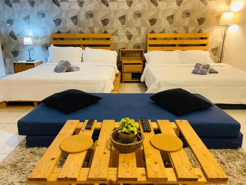 Cette chambre comprend 2 lits et une table. dans l'établissement Subang Jaya/ Da Men, Cozy Homestay/ Sunway, à Subang Jaya