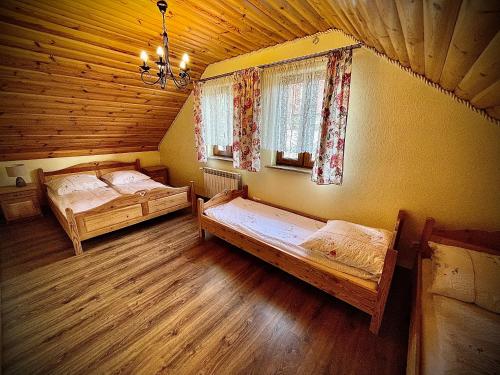 1 Schlafzimmer mit 2 Betten in einem Holzhaus in der Unterkunft Domki Istebna 1544 in Istebna