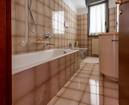 y baño con bañera y lavamanos. en MAD SERIATE - Appartamento Madonna delle Nevi, en Seriate