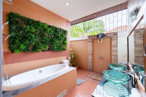 a bathroom with a tub and a green wall at Majestic Residence Pool Villa 4 Bedrooms Private Beach in Pattaya South