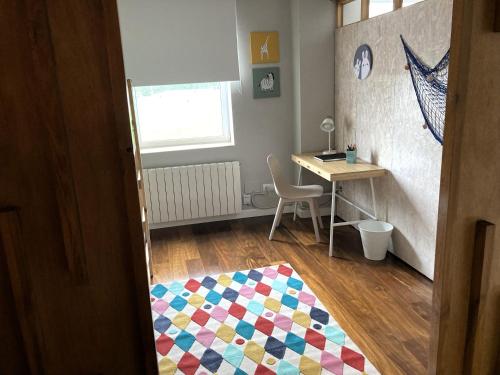 a room with a desk and a table and a rug at Apartamento El Espigón (Cimadevilla) in Gijón