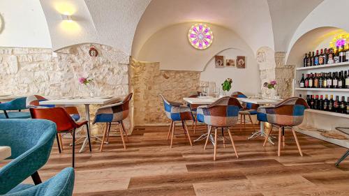 een restaurant met tafels en stoelen en een plank met wijnflessen bij La Dimora U Curdunn in Locorotondo