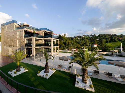 un complejo con palmeras frente a un edificio en Villa Elysium Park & SPA, en Batumi