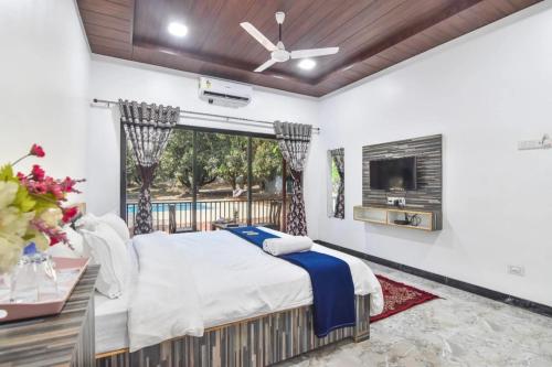 sypialnia z dużym łóżkiem i telewizorem w obiekcie Rise 6Bhk VIlla Alibaug w mieście Alibag