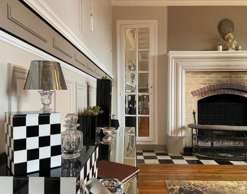 a living room with a fireplace and a checkered floor at L’orée du bois des rois in Ury