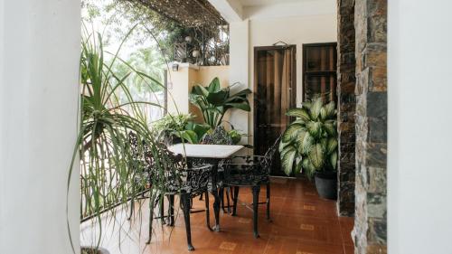 tavolo e sedie in una stanza con piante di Delle Suites a General Santos