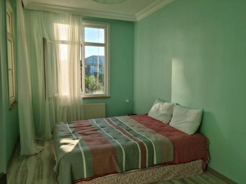 una camera verde con un letto e una finestra di 4 floors 8 beds villa a Beylikdüzü