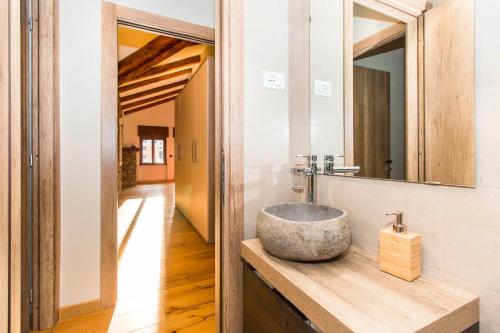 une salle de bain avec un lavabo en pierre et un miroir dans l'établissement Appartamento sulla piazzetta centrale, à Sauze dʼOulx