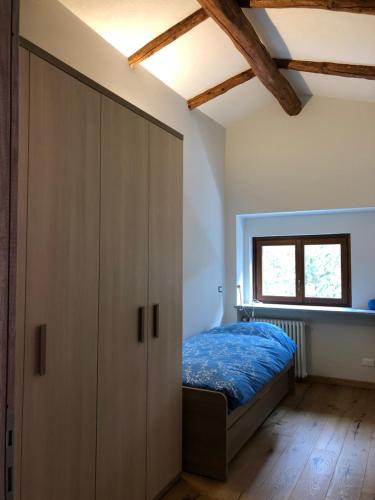 - une chambre avec un lit et une armoire dans l'établissement Appartamento sulla piazzetta centrale, à Sauze dʼOulx