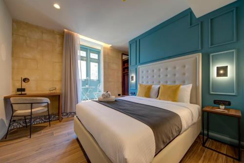 a bedroom with a large bed with a blue headboard at 23 Boutique Hotel in Il-Furjana