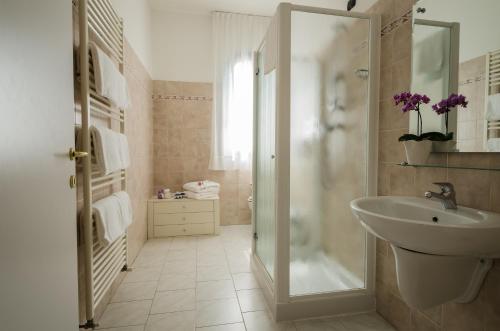 y baño blanco con lavabo y ducha. en Hotel Luna Blu, en Casumaro