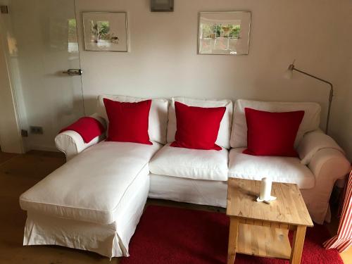 a living room with a white couch with red pillows at Landhaus Constantin Luxus-Appartments in Berchtesgaden