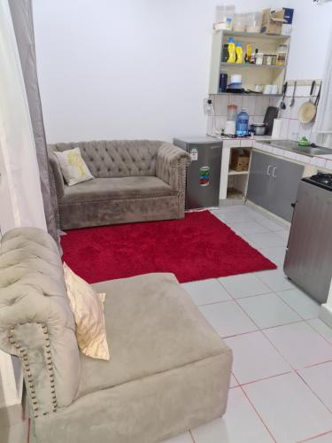 a living room with a couch and a red rug at ADIA APARTMENTS in Mombasa