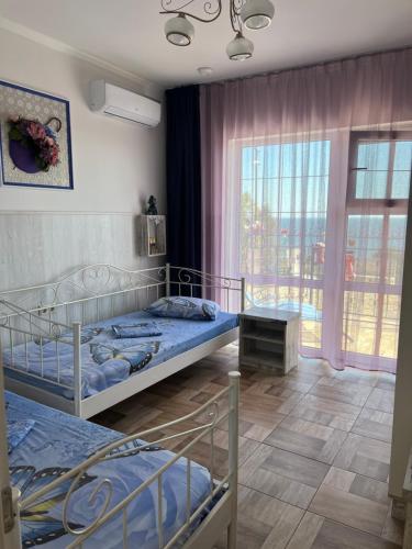 a bedroom with two beds and a large window at Flower Breeze in Chebanka