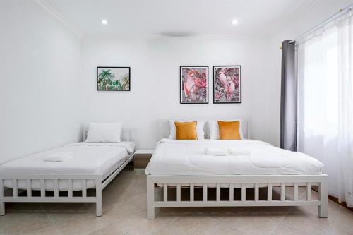2 camas en una habitación con paredes blancas en Majestic Residence Pool Villa 4 Bedrooms Private Beach en Pattaya South