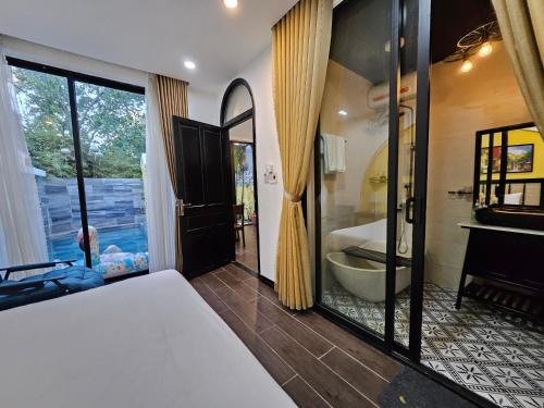 - une chambre avec une salle de bains pourvue d'une baignoire et de toilettes dans l'établissement Rosie Villa Hội An, à Hội An