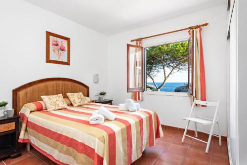 a bedroom with a bed with a view of the ocean at Villa Nayade in Cala en Blanes
