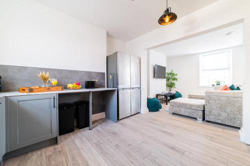 a kitchen with a refrigerator and a couch in a room at The Dunes, Porthcawl in Newton