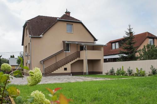 a house with a staircase in a yard at Madison Vendégház 1 in Kisvárda