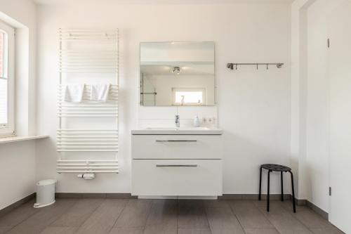 Baño blanco con lavabo y espejo en Appartement Olivia en Westerland