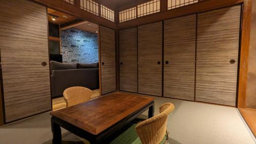una sala da pranzo con tavolo e sedie in legno di SIDOU 　INN a Onomichi