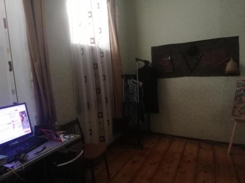 een kamer met een laptop op een bureau naast een deur bij квартира in Tbilisi City