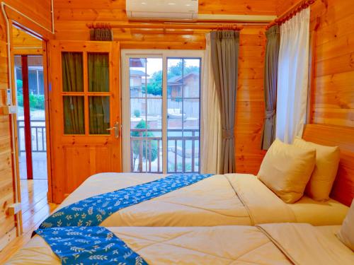 a bedroom with a large bed and a balcony at Soundless Resort in Khao Kho