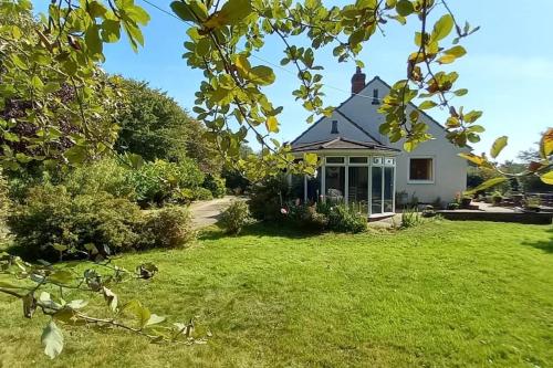 a house with a green yard with a house at Millfields cottage and garden in Goxhill