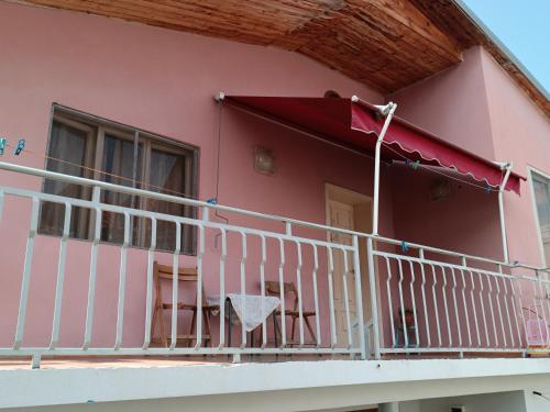 a balcony of a pink house with a white railing at Sermi's House in Shkodër