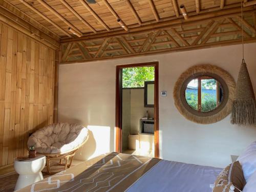 a bedroom with a bed and a mirror and a chair at Nusava Boutique Hotel in Nusa Penida
