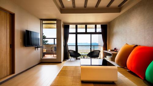 Una sala de estar con un sofá y vista al mar. en 宵待ちの宿　萩一輪, en Hagi